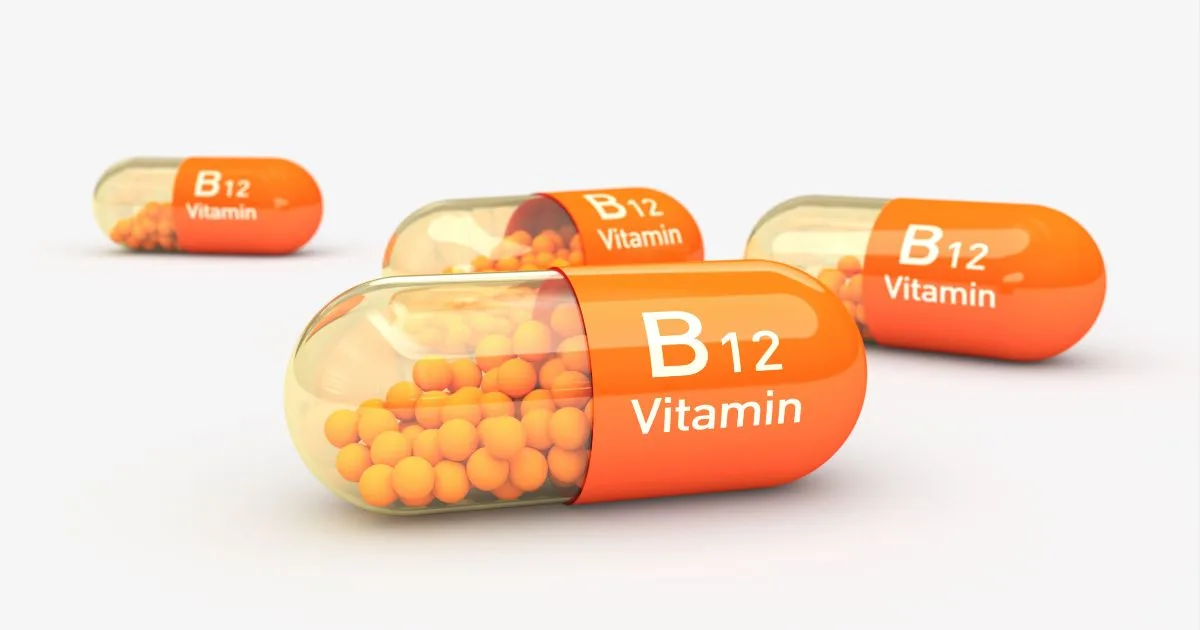 Healthcare professional in gloves preparing a vitamin B12 injection by drawing liquid from a vial into a syringe.
